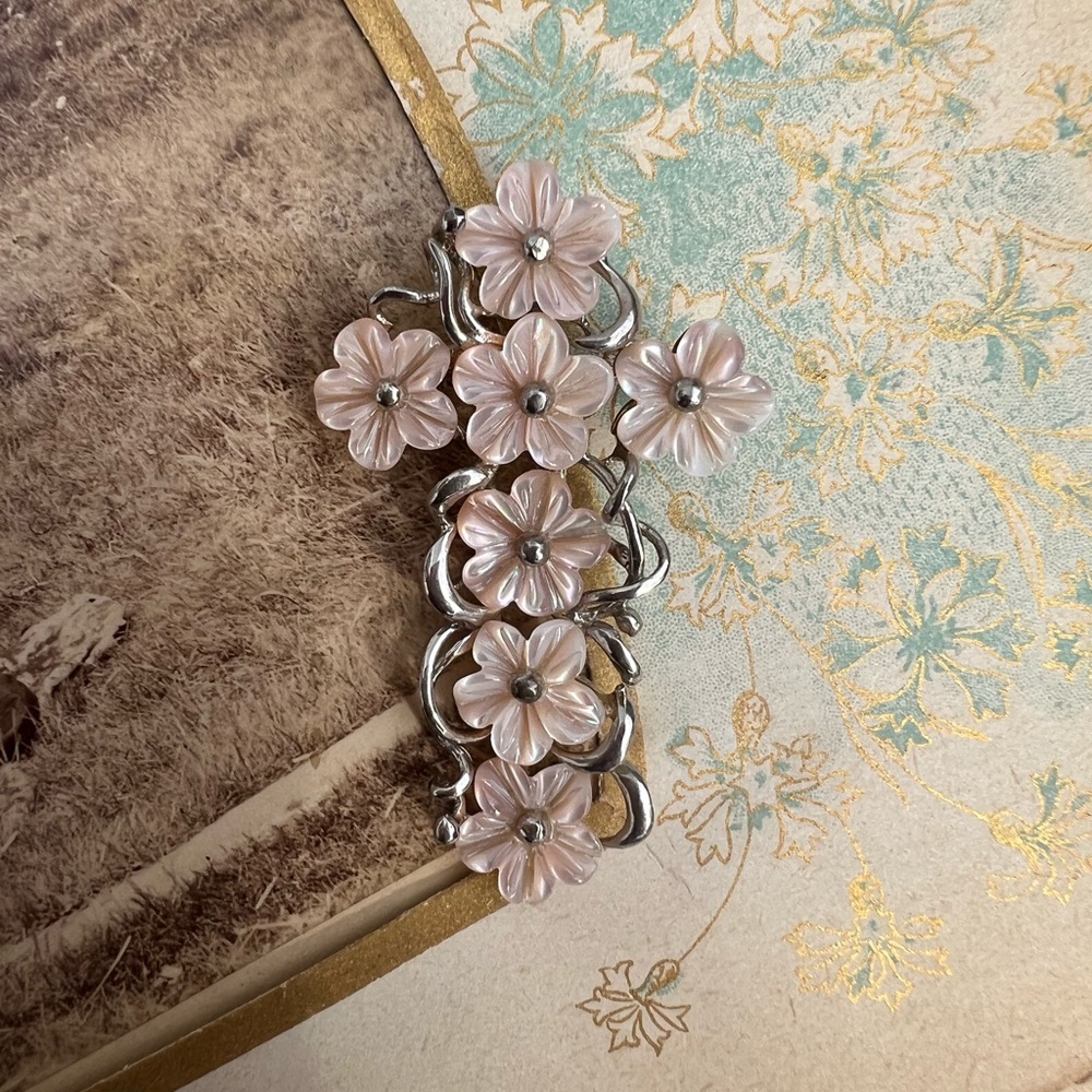 Pretty artisan crafted silver shell floral cross